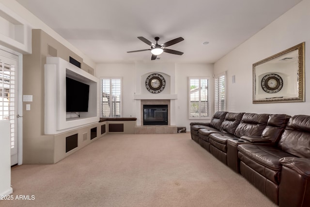 carpeted living area with visible vents, a ceiling fan, and a fireplace