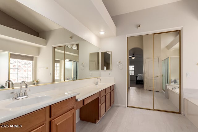 full bathroom with double vanity, a shower stall, a bath, and a sink