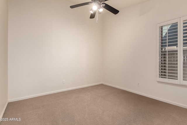 carpeted empty room featuring a ceiling fan and baseboards