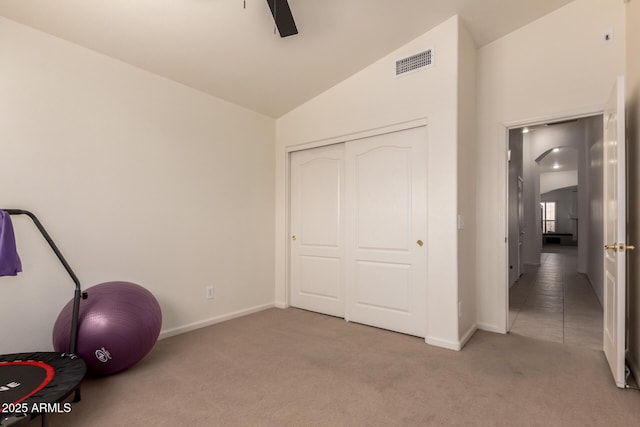 workout room featuring visible vents, carpet floors, baseboards, and vaulted ceiling