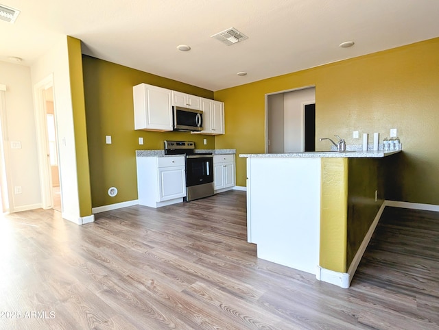 3760 N La Paz Dr, Eloy, AZ 85131 - kitchen featuring white cabinetry, visible vents, wood finished floors, and appliances with stainless steel finishes