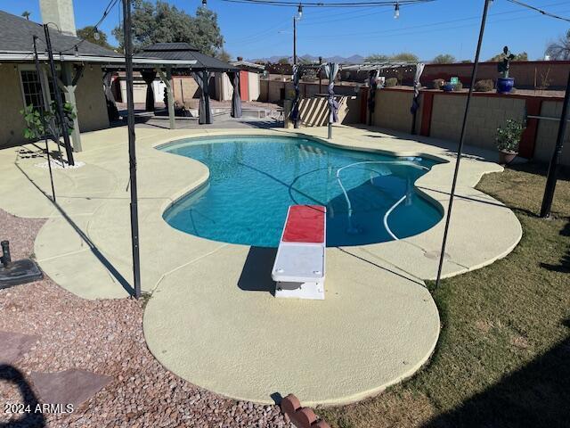 view of pool featuring a gazebo, a diving board, and a patio