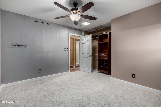 unfurnished bedroom with ceiling fan, light carpet, and a closet