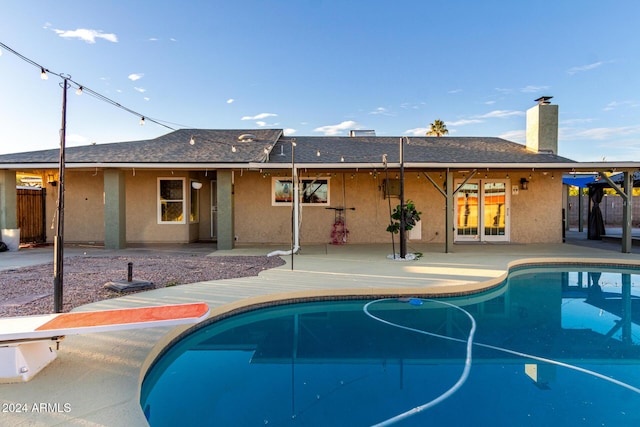 view of pool with a patio area and a diving board