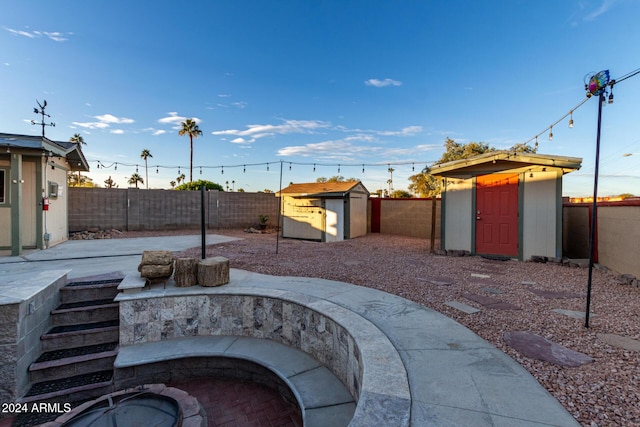 view of patio / terrace featuring a shed and an outdoor fire pit