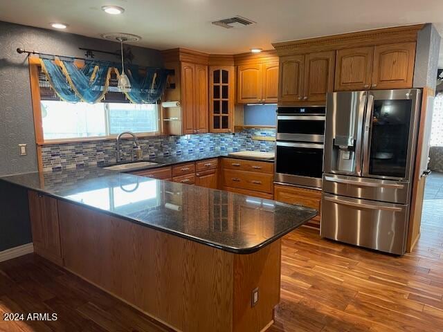 kitchen with pendant lighting, sink, kitchen peninsula, and stainless steel appliances