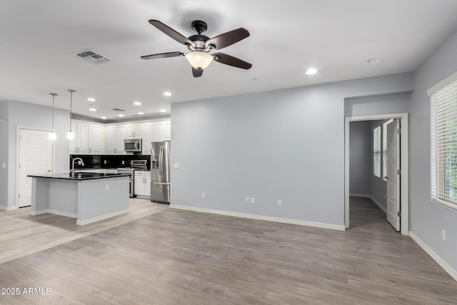 5550 N 16th St Unit 166, Phoenix, AZ 85016 - kitchen featuring stainless steel appliances, dark countertops, a ceiling fan, light wood-type flooring, and recessed lighting