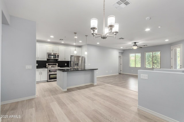 5550 N 16th St Unit 166, Phoenix, AZ 85016 - kitchen with appliances with stainless steel finishes, a ceiling fan, open floor plan, dark countertops, and white cabinetry