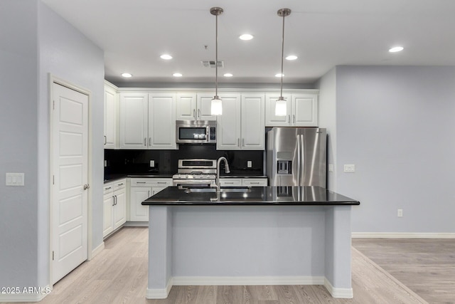 5550 N 16th St Unit 166, Phoenix, AZ 85016 - kitchen featuring appliances with stainless steel finishes, dark countertops, light wood finished floors, white cabinets, and recessed lighting