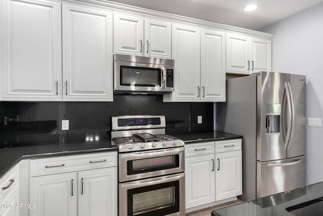 5550 N 16th St Unit 166, Phoenix, AZ 85016 - kitchen featuring appliances with stainless steel finishes, dark countertops, tasteful backsplash, white cabinets, and recessed lighting