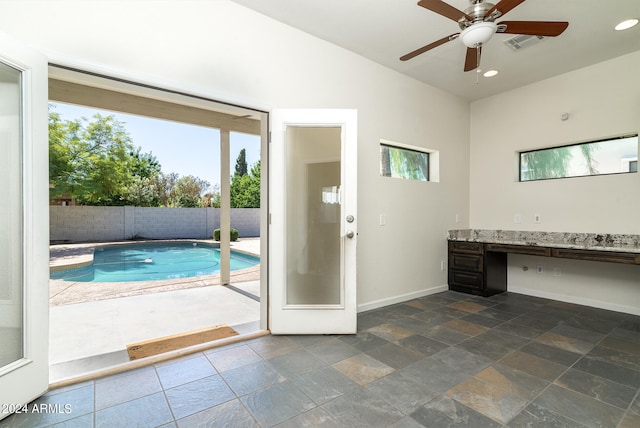 interior space featuring built in desk and ceiling fan