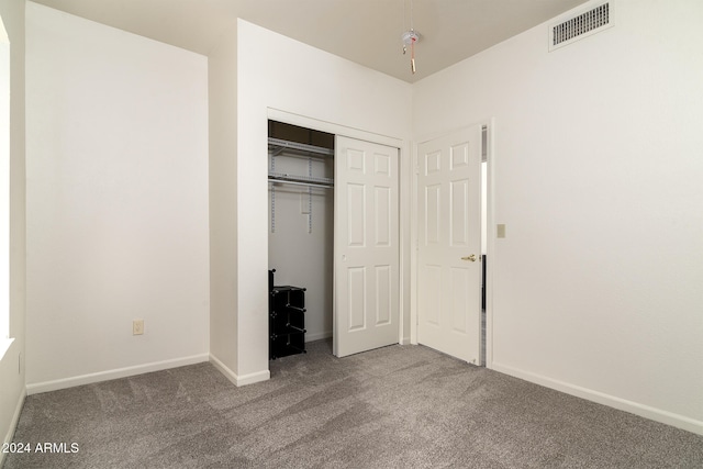 unfurnished bedroom featuring carpet flooring and a closet