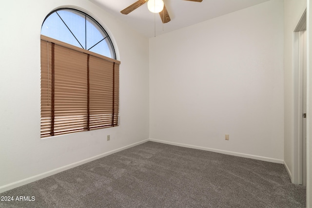 unfurnished room featuring dark colored carpet and ceiling fan