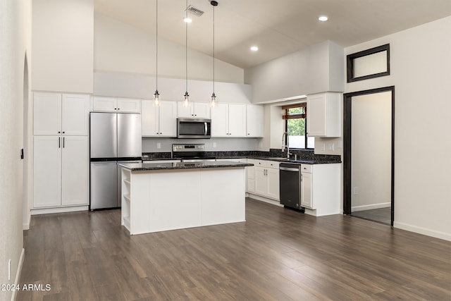 kitchen with hanging light fixtures, dark hardwood / wood-style flooring, high vaulted ceiling, and appliances with stainless steel finishes