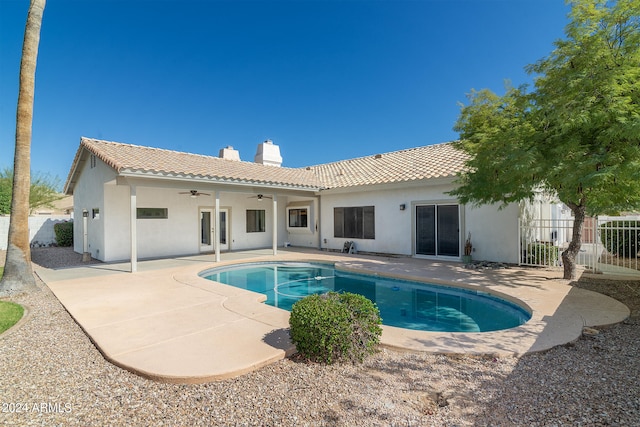 back of property featuring ceiling fan, a patio, and a fenced in pool