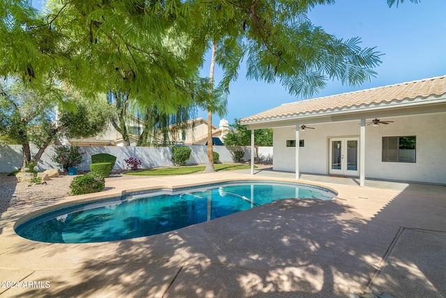 view of swimming pool with ceiling fan, a patio, and french doors