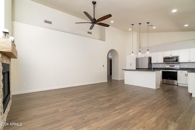 unfurnished living room featuring a fireplace, dark hardwood / wood-style flooring, ceiling fan, and high vaulted ceiling