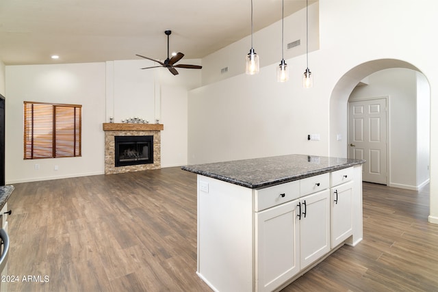 kitchen featuring dark wood-type flooring, pendant lighting, high vaulted ceiling, white cabinetry, and dark stone countertops