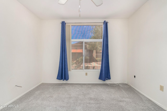 carpeted spare room featuring ceiling fan