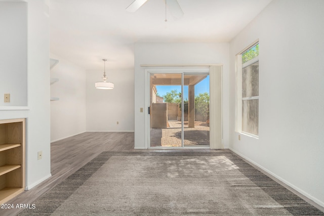 unfurnished living room featuring ceiling fan and dark hardwood / wood-style floors