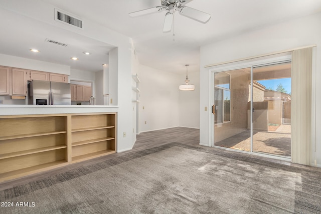 unfurnished living room featuring ceiling fan and dark wood-type flooring