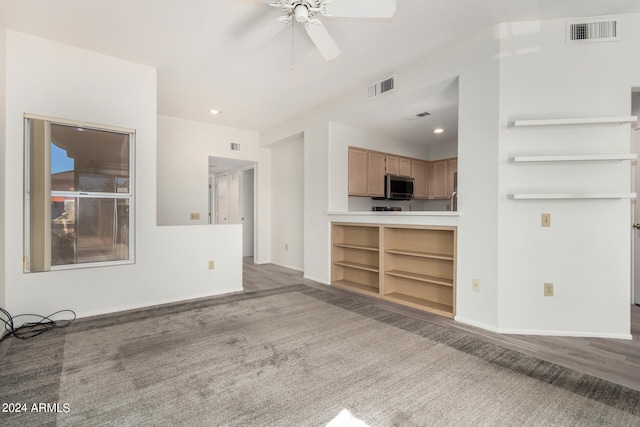 unfurnished living room with ceiling fan and hardwood / wood-style flooring