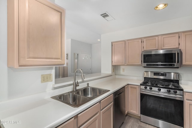 kitchen featuring light hardwood / wood-style flooring, stainless steel appliances, light brown cabinetry, and sink