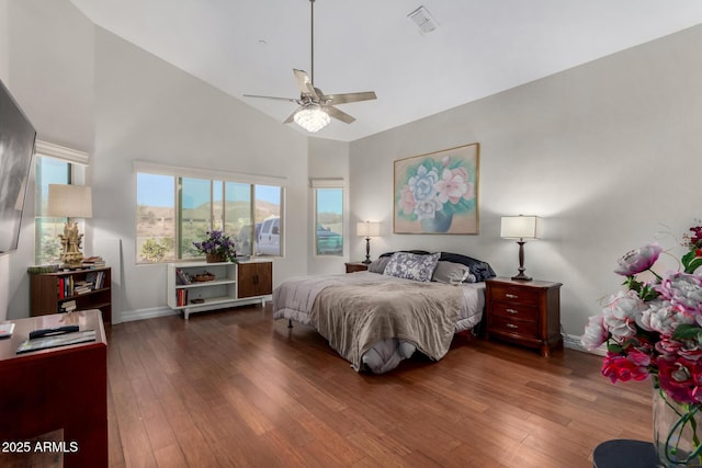 bedroom featuring hardwood / wood-style flooring, high vaulted ceiling, ceiling fan, and baseboards