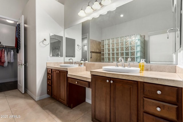 bathroom with double vanity, tile patterned floors, walk in shower, and a spacious closet