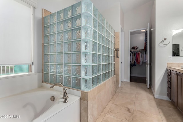 full bathroom with a walk in shower, a bath, vanity, a spacious closet, and tile patterned floors