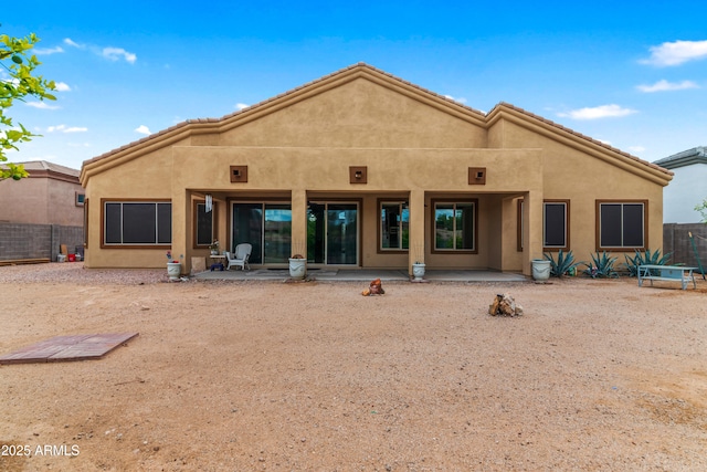 back of property featuring stucco siding, a patio, and fence
