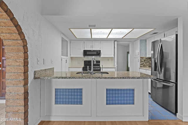 2916 S Revere Cir, Mesa, AZ 85210 - kitchen featuring stainless steel fridge, black microwave, a sink, and light stone counters
