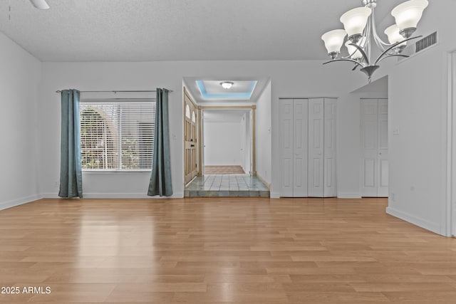 2916 S Revere Cir, Mesa, AZ 85210 - empty room with light wood-style floors, a chandelier, and baseboards