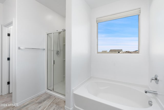 bathroom featuring shower with separate bathtub, plenty of natural light, and hardwood / wood-style floors