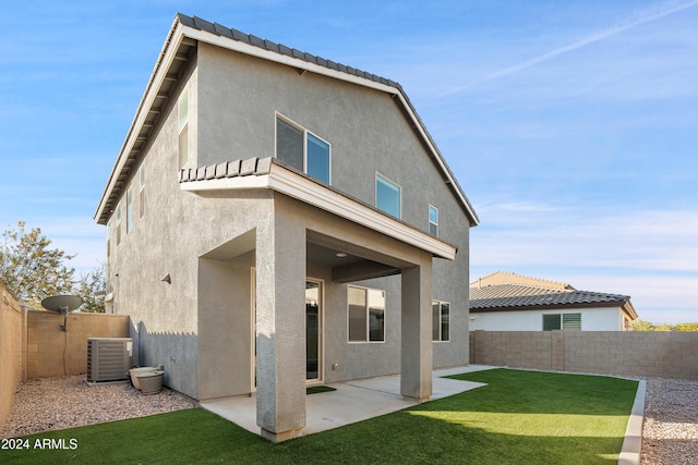 rear view of house featuring a yard, cooling unit, and a patio area