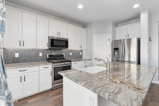 kitchen featuring white cabinetry, sink, appliances with stainless steel finishes, and an island with sink