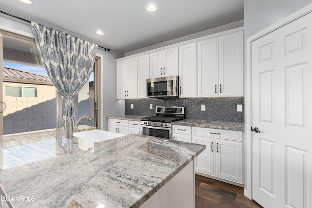 kitchen featuring light stone countertops, sink, white cabinets, and stainless steel appliances