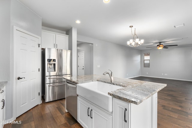 kitchen featuring a kitchen island with sink, white cabinets, light stone counters, and appliances with stainless steel finishes