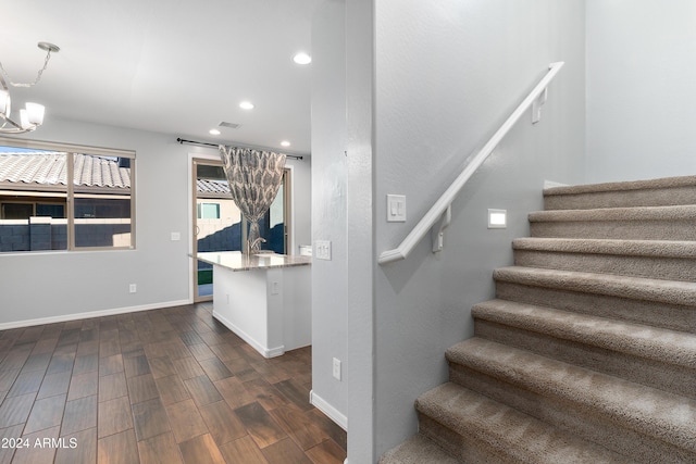 stairway with a notable chandelier