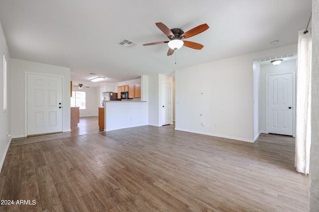 unfurnished living room featuring ceiling fan and hardwood / wood-style floors