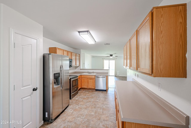 kitchen featuring ceiling fan, sink, kitchen peninsula, stainless steel appliances, and light brown cabinetry