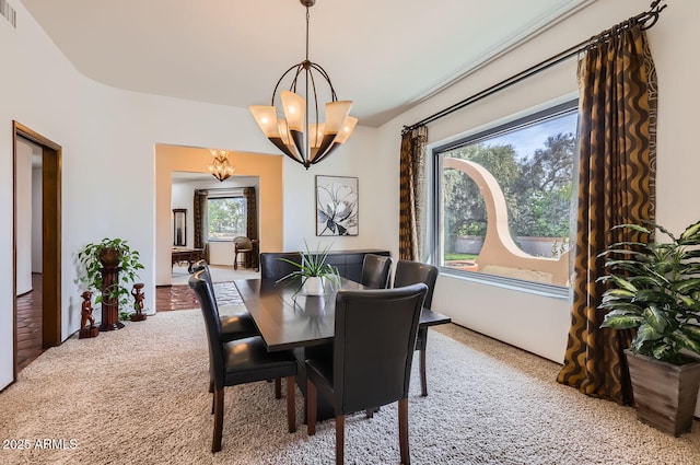 dining area with an inviting chandelier and carpet