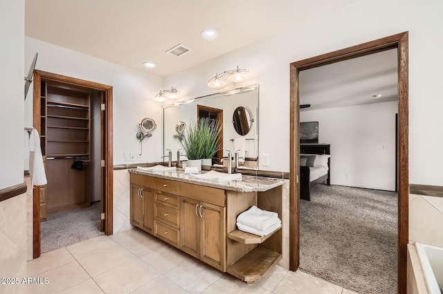 bathroom featuring a tub to relax in, vanity, and tile patterned flooring