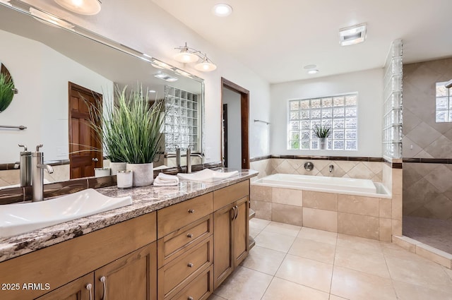 bathroom with tile patterned floors, shower with separate bathtub, and vanity