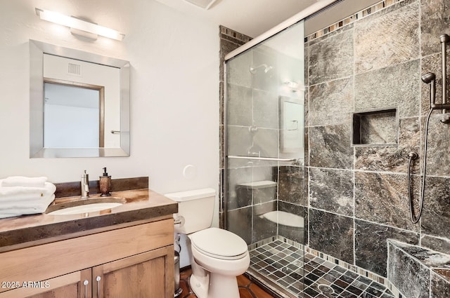 bathroom with a shower with door, vanity, and toilet