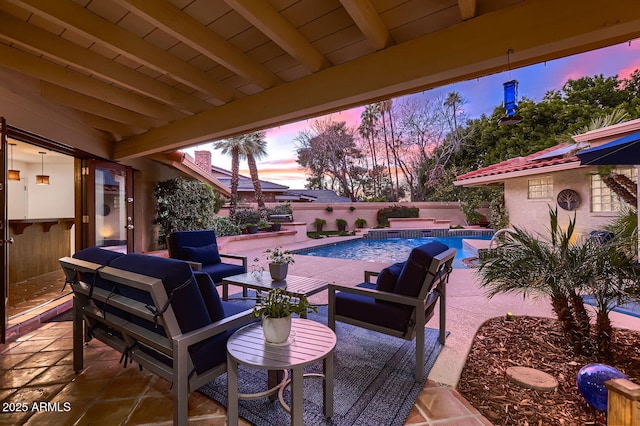 patio terrace at dusk featuring a fenced in pool and pool water feature