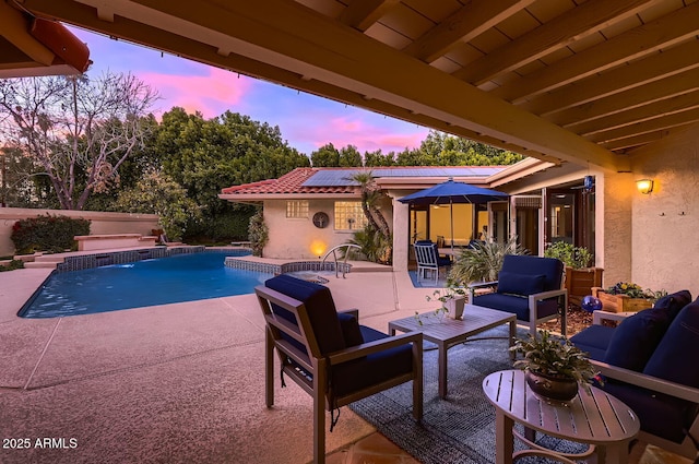 pool at dusk featuring outdoor lounge area and a patio