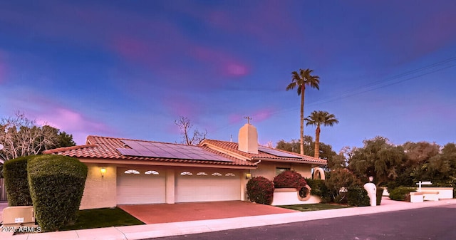 view of front of home featuring a garage and solar panels