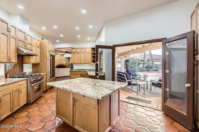 kitchen featuring a center island, high end stainless steel range, and light stone countertops