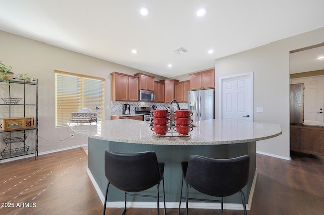 kitchen featuring stainless steel appliances, dark hardwood / wood-style flooring, and a center island